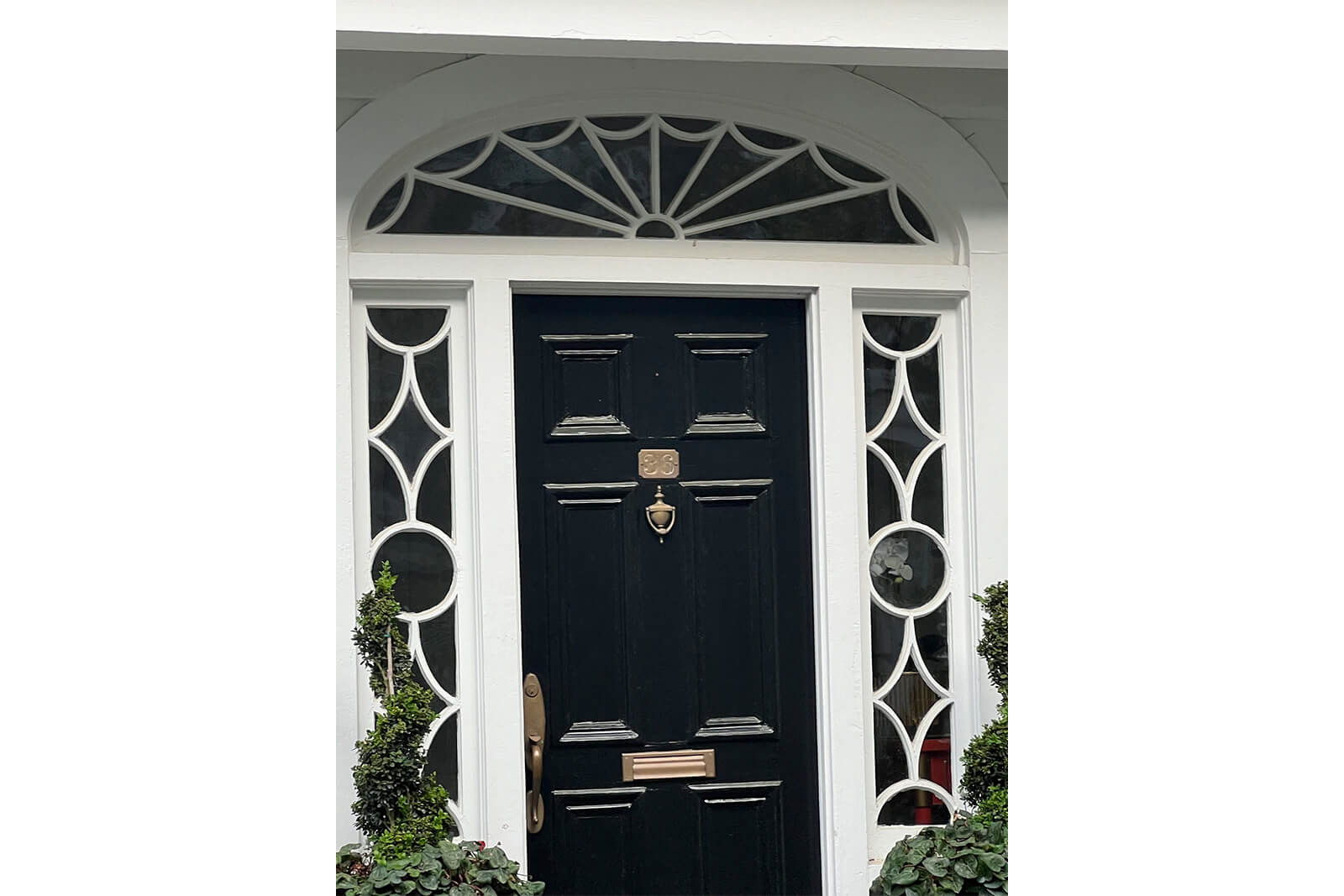 Black front door with architectural moldings around it